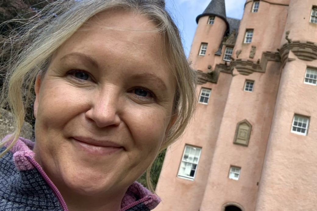 Woman in front of castle in Scotland. HomeExchange for teachers.